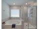 Clean and modern bathroom featuring a tub and a glass enclosed shower with marble tile at 647 R L Stowe Rd, Belmont, NC 28012
