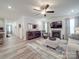 Bright living room with fireplace, ceiling fan, wood floors, and comfortable seating area at 647 R L Stowe Rd, Belmont, NC 28012