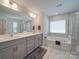 Bright main bathroom featuring double sinks, a soaking tub, and a glass-enclosed shower at 647 R L Stowe Rd, Belmont, NC 28012