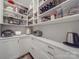 Walk-in pantry with white cabinetry and countertop offers ample storage and organization at 647 R L Stowe Rd, Belmont, NC 28012