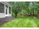 Beautiful backyard featuring a well-maintained lawn, mature trees, privacy fence and screened porch, creating a serene outdoor space at 6632 Hawksnest Dr, Charlotte, NC 28269