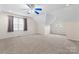 Spacious bonus room with vaulted ceilings, plush carpeting, window, and ceiling fan at 6632 Hawksnest Dr, Charlotte, NC 28269