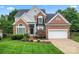 Charming two-story brick home with well-manicured lawn and attached two-car garage at 6632 Hawksnest Dr, Charlotte, NC 28269