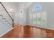 Bright foyer with hardwood floors and staircase leads to a large window at 6632 Hawksnest Dr, Charlotte, NC 28269