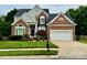 Charming brick home with a well-manicured lawn, attached two-car garage, and inviting front entrance at 6632 Hawksnest Dr, Charlotte, NC 28269