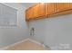 Functional laundry room featuring tile floors, cabinets, and a window at 6632 Hawksnest Dr, Charlotte, NC 28269