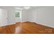 This bedroom has hardwood floors, a ceiling fan, and a window view to the outside at 7213 Lancer Dr, Charlotte, NC 28226