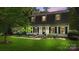 Charming two-story home featuring a lush green lawn, mature trees, and classic black shutters at 7213 Lancer Dr, Charlotte, NC 28226