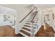 Elegant stairway with dark wood treads and white risers, leading to an open living area at 7213 Lancer Dr, Charlotte, NC 28226