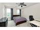 Well-lit bedroom with two large windows, a ceiling fan, carpet, desk, and comfortable chair at 7434 Dover Mill Sw Ln, Concord, NC 28025
