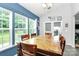 Bright dining room featuring a large wooden table, blue accent wall, and plenty of natural light from several windows at 7434 Dover Mill Sw Ln, Concord, NC 28025