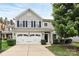 Charming two-story home featuring a two-car garage, complemented by a well-maintained front lawn and mature tree at 7434 Dover Mill Sw Ln, Concord, NC 28025