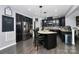 Modern kitchen with dark cabinetry, granite countertops, stainless steel appliances, and a center island with bar seating at 7434 Dover Mill Sw Ln, Concord, NC 28025