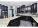 Gourmet kitchen with dark cabinets, granite counters, stainless steel appliances, and a tiled backsplash for culinary enthusiasts at 7434 Dover Mill Sw Ln, Concord, NC 28025