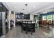 Spacious kitchen with dark cabinets, stainless steel appliances, granite counters, and an island flows into the dining area at 7434 Dover Mill Sw Ln, Concord, NC 28025