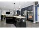 Open kitchen with a center island, stainless steel appliances, dark cabinetry, and seamless flow into the dining and living spaces at 7434 Dover Mill Sw Ln, Concord, NC 28025