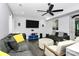 Comfortable living room features dark hardwood floors, a ceiling fan, and a large TV for entertainment at 7434 Dover Mill Sw Ln, Concord, NC 28025