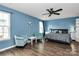 Bright main bedroom with a ceiling fan, light blue walls, and two comfortable armchairs next to the bed at 7434 Dover Mill Sw Ln, Concord, NC 28025