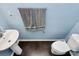 Cozy powder room features a pedestal sink, toilet, and a towel rack on a light blue wall at 7434 Dover Mill Sw Ln, Concord, NC 28025