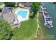 Aerial view of a community pool, marina, and waterfront with lush greenery and boat slips at 7881 Mariners Pointe Cir, Denver, NC 28037