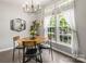 Charming dining area featuring a modern chandelier, oval table, and bright windows at 7881 Mariners Pointe Cir, Denver, NC 28037