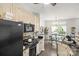 Modern kitchen featuring black appliances, tile backsplash, and an adjacent breakfast nook at 7881 Mariners Pointe Cir, Denver, NC 28037