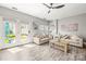 Bright living room features neutral-toned sofas and decor, complemented by modern flooring and natural light at 7881 Mariners Pointe Cir, Denver, NC 28037