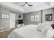 A stylish main bedroom featuring neutral tones, a tray ceiling, and plush white bedding at 7881 Mariners Pointe Cir, Denver, NC 28037