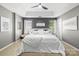 A stylish main bedroom featuring neutral tones, a tray ceiling, and plush white bedding at 7881 Mariners Pointe Cir, Denver, NC 28037