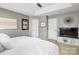 A stylish main bedroom featuring neutral tones, a tray ceiling, and plush white bedding at 7881 Mariners Pointe Cir, Denver, NC 28037