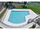 Aerial view of a community pool surrounded by deck chairs and lush green landscaping at 7881 Mariners Pointe Cir, Denver, NC 28037
