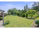 Lush backyard with green lawn, ornamental trees, and an iron fence creating a private retreat at 8340 Breton Way, Harrisburg, NC 28075