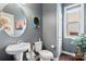 Bathroom with a pedestal sink, hardwood floors, and a decorative round mirror at 8340 Breton Way, Harrisburg, NC 28075