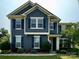 Inviting two-story home featuring a well-manicured lawn, complemented by vibrant shrubs and beautiful blooming flowers at 8340 Breton Way, Harrisburg, NC 28075