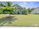 Charming two-story home boasts lush green lawn and mature trees in a well-maintained front yard at 8340 Breton Way, Harrisburg, NC 28075