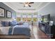 Comfortable main bedroom with hardwood floors, ceiling fan, sitting area, and large windows with views at 8340 Breton Way, Harrisburg, NC 28075