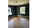 Bedroom with two windows and aged hardwood floors presenting an opportunity for renovation at 839 S Chester St, Gastonia, NC 28052