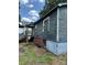 Side view of the house with weathered wood siding and a brick foundation, showing signs of repair at 839 S Chester St, Gastonia, NC 28052