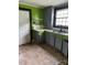 Dated kitchen with green walls, gray cabinets, and worn flooring needing repairs at 839 S Chester St, Gastonia, NC 28052