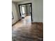 Empty living room with hardwood floors and a doorway, showing signs of wear and needing TLC at 839 S Chester St, Gastonia, NC 28052