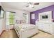 Bright bedroom with a purple accent wall, white furniture, and colorful polka-dot bedding at 925 Skywatch Ln, Monroe, NC 28112