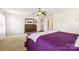 Spacious bedroom featuring plush carpeting, a ceiling fan, and purple accent decor at 925 Skywatch Ln, Monroe, NC 28112