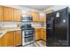 Kitchen with wood cabinets, modern appliances including a stainless steel oven, and a black refrigerator at 925 Skywatch Ln, Monroe, NC 28112