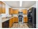 Well-lit kitchen featuring wood cabinets, modern appliances, and stainless steel microwave and oven at 925 Skywatch Ln, Monroe, NC 28112