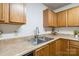 Close-up of the kitchen sink and countertop, featuring wood cabinets and a stainless steel faucet at 925 Skywatch Ln, Monroe, NC 28112