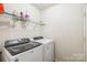 Laundry room featuring a white washer, dryer, and shelving for storage of supplies at 925 Skywatch Ln, Monroe, NC 28112