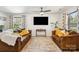 Comfortable living room featuring two brown leather sofas, a decorative rug and an entertainment center at 925 Skywatch Ln, Monroe, NC 28112
