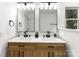 Bathroom featuring a double vanity with modern lighting and wood cabinets at 9513 Saddle Run Trl, Charlotte, NC 28269