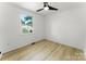 Bright bedroom with light wood floors, ceiling fan, and a large window at 9513 Saddle Run Trl, Charlotte, NC 28269