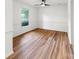 Bright, empty bedroom featuring hardwood floors, white walls, window and ceiling fan at 9513 Saddle Run Trl, Charlotte, NC 28269